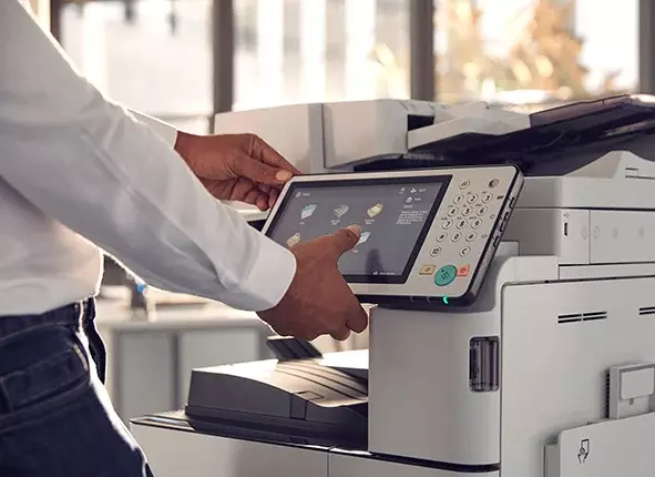 Henkilö käyttää tulostinta, jossa digitaalinen värinäyttö.