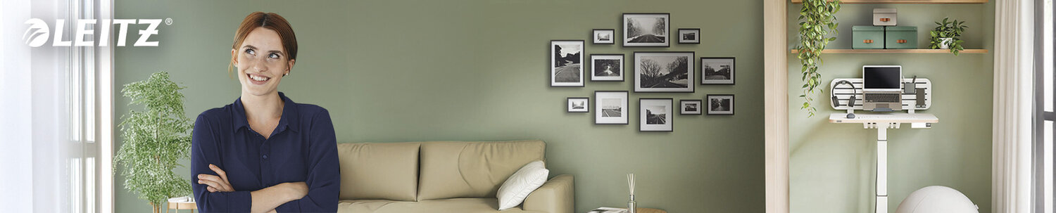 Hymyilevä nuori nainen ergonomisessa kotitoimistossaan.