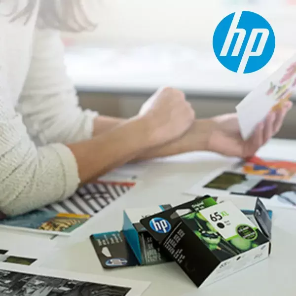 Nuori nainen hymyilee tyytyväisenä ergonomisessa työpisteessään.