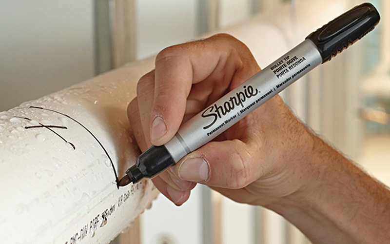Käsi kirjoittaa Sharpie-kynällä